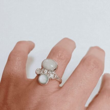 Anillo de plata artesanal con piedra luna ovalada y calcedonia azul claro en engaste circular