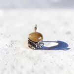 colgante de piedra del sol en plata 950, destacando el detalle de las hojas talladas y la profundidad de la piedra