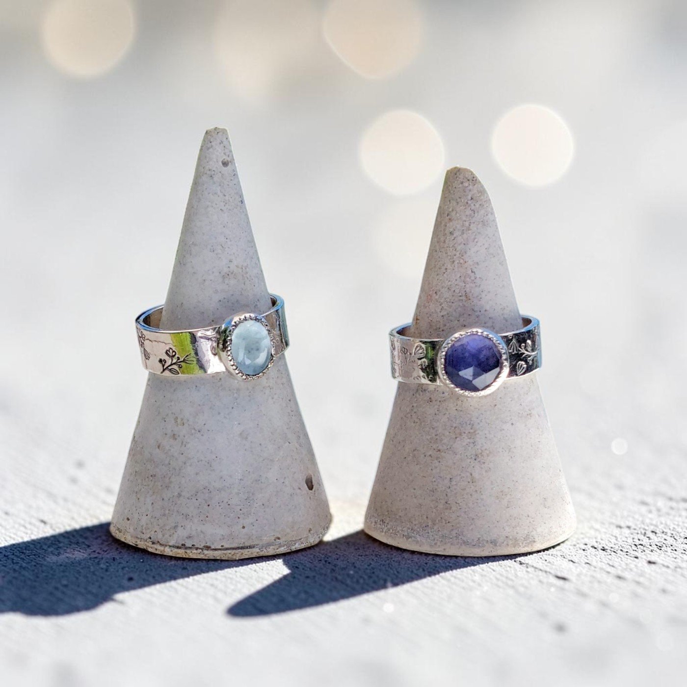 Anillos Ori de plata 950 con iolita y otro con aguamarina en dos conos de cemento. Plata 950 -Plataia