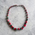 Collar de turquesa tibetana, coral y plata sobre cemento gris