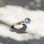 Anillo Axia con topacio celeste engastado y moissanitas laterales