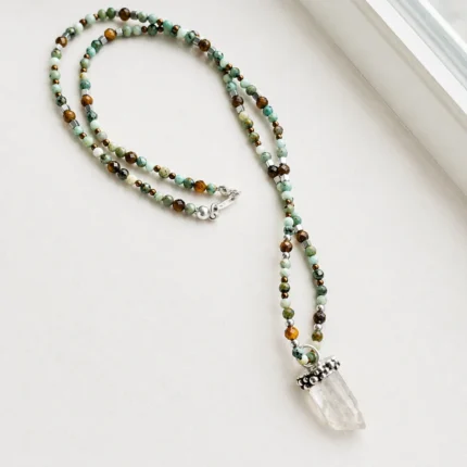 Collar de piedras naturales con turquesa tibetana, amazonita, ojo de tigre y bolitas de plata, con colgante de cuarzo cristal natural en bruto y engaste de plata hecho a mano.