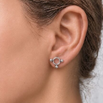 Aros pequeños de plata Círculo Balls: vista de un aro de 1,2 cm colocado en el lóbulo de una modelo.